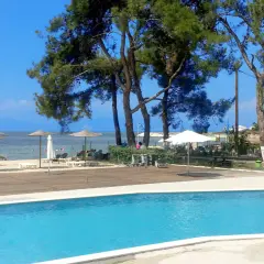 Basen i plaża z parasolami przy hotelu Rachoni Imperial. Idealne miejsce na relaks.