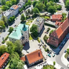 Słupsk atrakcje na weekend: zamek Książąt Pomorskich i kościół Mariacki z lotu ptaka. Zielone dachy i czerwona cegła tworzą malowniczy widok.