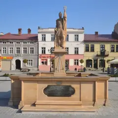 Pomnik na żywiec rynku, z kolorowymi kamienicami w tle.