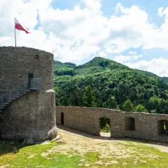 Kamienna wieża z polską flagą i malownicze wzgórza. Rytro atrakcje zachwycają widokami i historią.