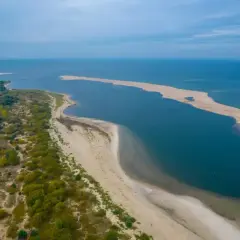Piękna piaszczysta mierzeja otoczona wodą, tworząca malowniczy krajobraz polskiego morza.
