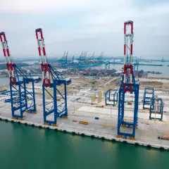 Ogromne dźwigi portowe na tle kontenerowców i statków. To serce logistyki, największe lotnisko w Europie dla towarów.