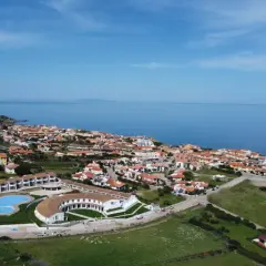 Widok z lotu ptaka na kurort GH Santina Resort z basenem i budynkami, nad morzem na Sardynii.