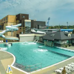 AquaCity Poprad: baseny, zjeżdżalnie wodne i leżaki pod błękitnym niebem.
