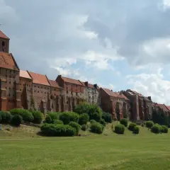 Grudziądz atrakcje na weekend: imponujące spichrze nad Wisłą, zielony teren rekreacyjny i malownicze niebo. Idealne miejsce na spacer.