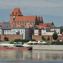 Widok na średniowieczny zespół miejski Torunia z Wisły, z katedrą i ceglanymi murami.