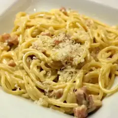 Pyszna carbonara, kremowa i bogata, z kawałkami boczku i posypana parmezanem. Idealna na szybki obiad.
