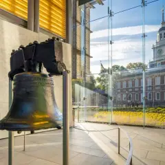 Liberty Bell w nowoczesnym wnętrzu, z widokiem na Independence Hall i kwitnące kwiaty.