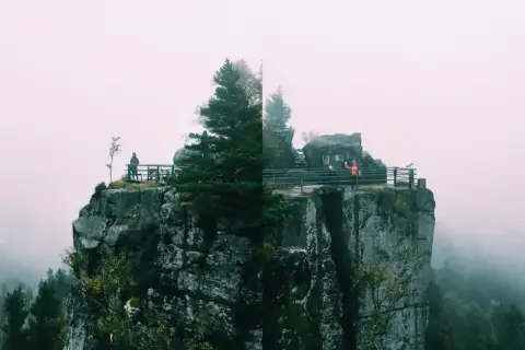 Widok na skalne miasto, gdzie karłów atrakcje przyciągają turystów. Mgła otula szczyty, tworząc mistyczną atmosferę.