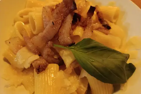 Pyszna carbonara z chrupiącym boczkiem, makaronem rigatoni i listkiem bazylii. Idealny boczek do carbonary to klucz do sukcesu.