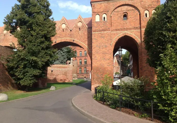 Brama w Sokołowie Podlaskim, ceglana architektura i zielone drzewa. Odkryj atrakcje tego miejsca!