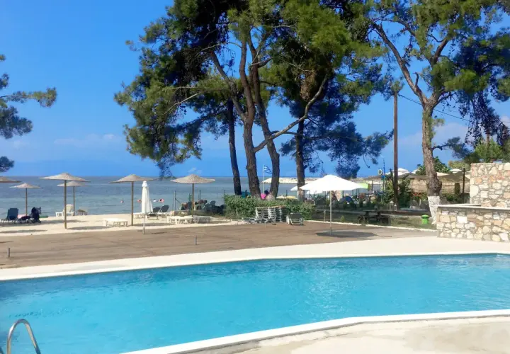 Basen i plaża z parasolami przy hotelu Rachoni Imperial. Idealne miejsce na relaks.