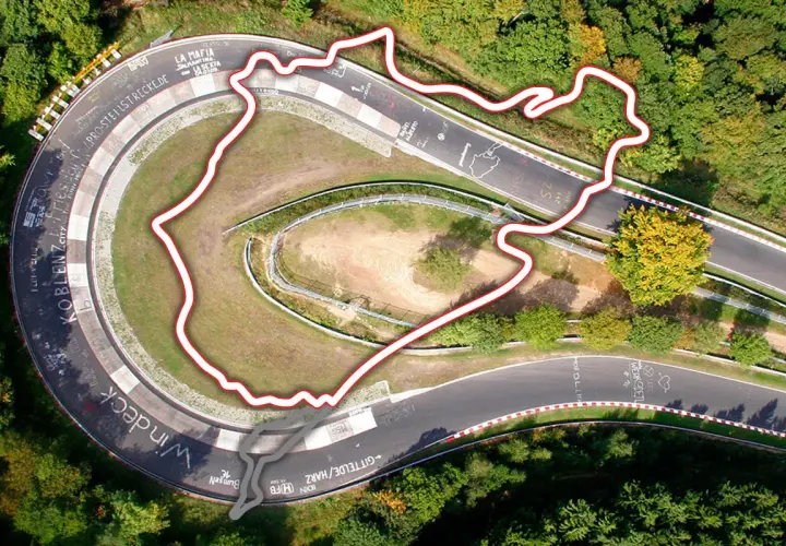 Widok z lotu ptaka na fragment toru Nürburgring otoczony lasem. Czerwona linia obrysowuje trasę, ukazując jej kręty kształt.