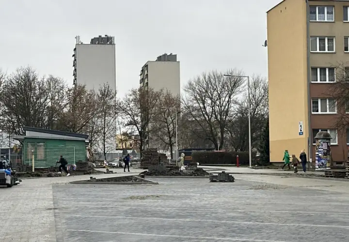 Prace brukarskie w Serbinowie. W tle bloki mieszkalne i zielona budka.