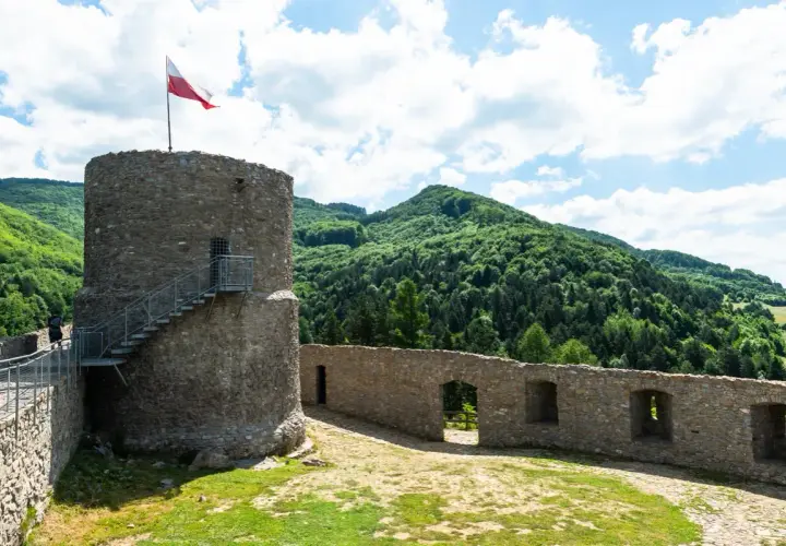 Kamienna wieża z polską flagą i malownicze wzgórza. Rytro atrakcje zachwycają widokami i historią.