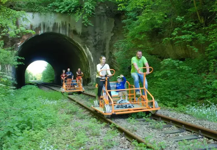 Rodzina na drezynach rowerowych przed tunelem w Bieszczadach.