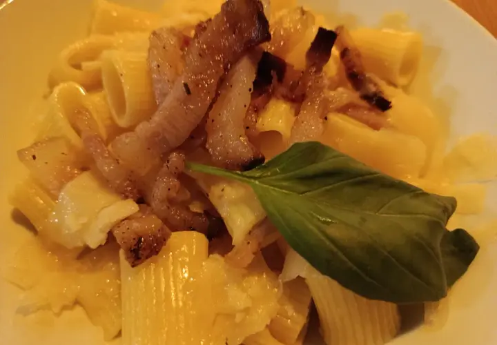 Pyszna carbonara z chrupiącym boczkiem, makaronem rigatoni i listkiem bazylii. Idealny boczek do carbonary to klucz do sukcesu.