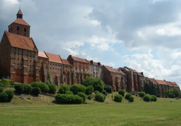 Grudziądz atrakcje na weekend: imponujące spichrze nad Wisłą, zielony teren rekreacyjny i malownicze niebo. Idealne miejsce na spacer.