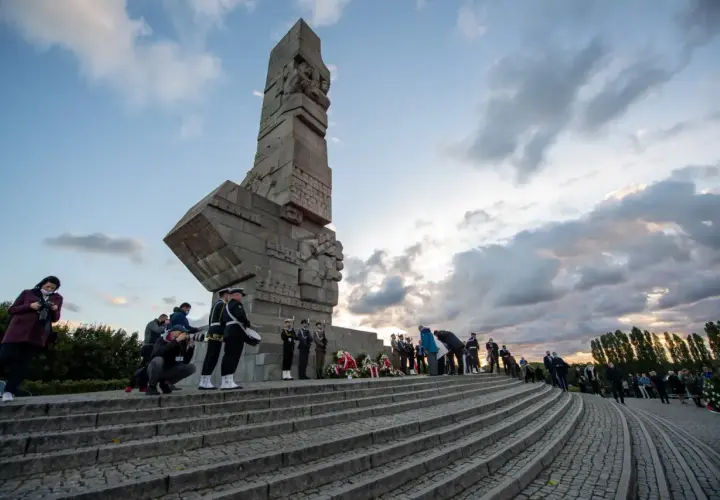 Uroczystość przy Pomniku Obrońców Wybrzeża na Westerplatte. W tle monumentalny monument, a na schodach delegacje i żołnierze.