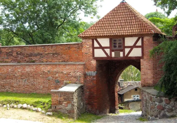 Brama miejska w Pasłęku, z charakterystycznym dachem i szachulcową nadbudową, to jedna z głównych atrakcji miasta.