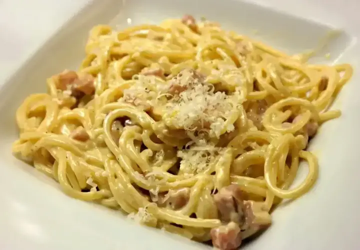 Pyszna carbonara, kremowa i bogata, z kawałkami boczku i posypana parmezanem. Idealna na szybki obiad.