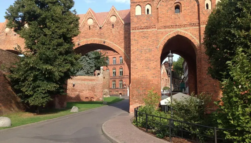 Brama w Sokołowie Podlaskim, ceglana architektura i zielone drzewa. Odkryj atrakcje tego miejsca!