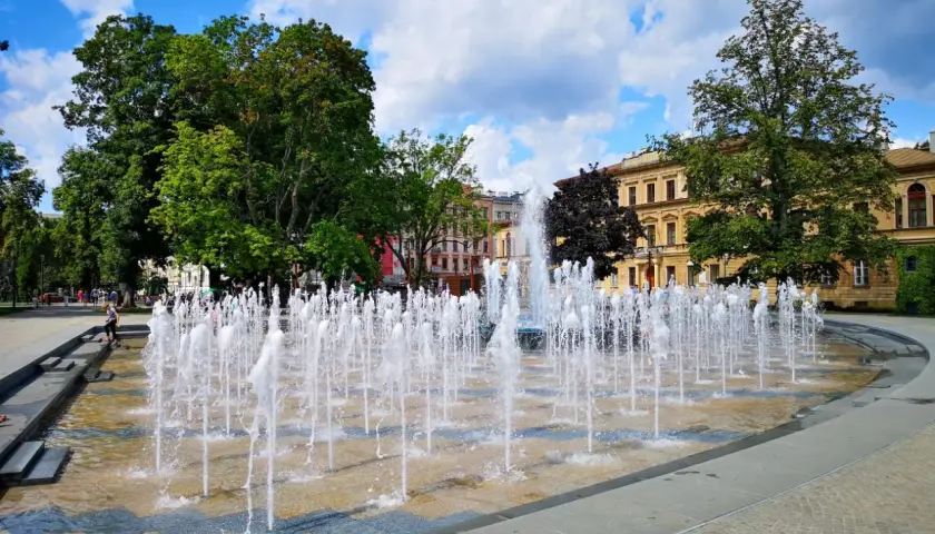 Plac Litewski w Lublinie tętni życiem, a fontanny tworzą wodny taniec na tle zabytkowych kamienic.