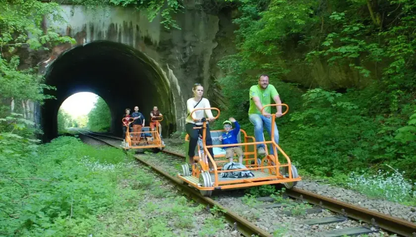 Rodzina na drezynach rowerowych przed tunelem w Bieszczadach.