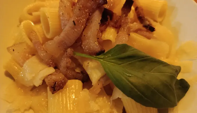 Pyszna carbonara z chrupiącym boczkiem, makaronem rigatoni i listkiem bazylii. Idealny boczek do carbonary to klucz do sukcesu.