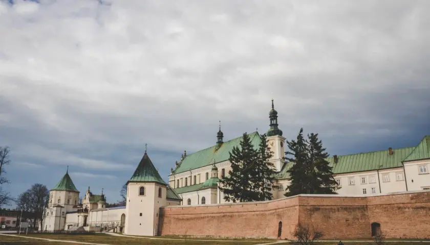 Bazylika w Leżajsku, jedna z głównych atrakcji miasta, z zielonymi dachami i ceglanym murem obronnym.
