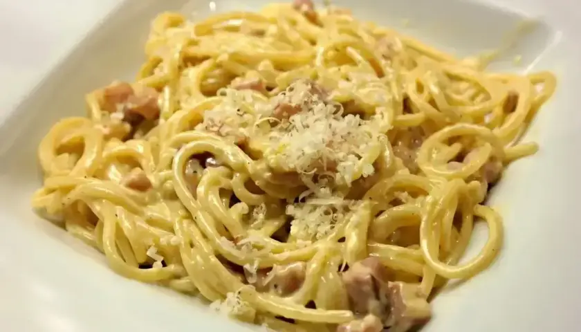 Pyszna carbonara, kremowa i bogata, z kawałkami boczku i posypana parmezanem. Idealna na szybki obiad.
