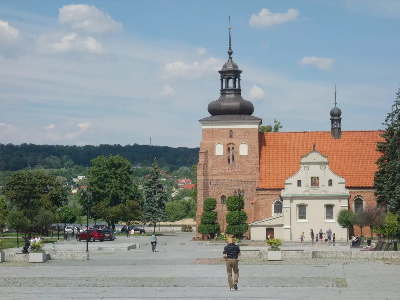 Włocławek atrakcje na weekend: plac z zabytkową katedrą, zielone parki i spacerujący ludzie.