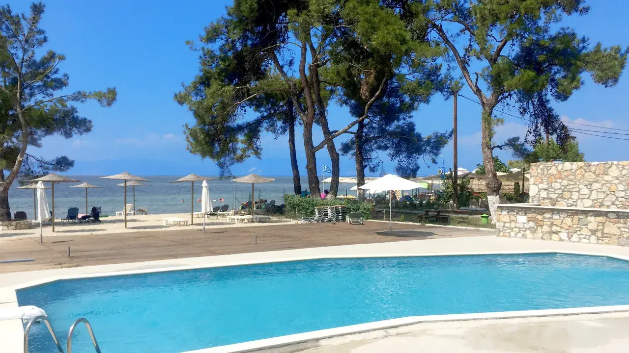 Basen i plaża z parasolami przy hotelu Rachoni Imperial. Idealne miejsce na relaks.