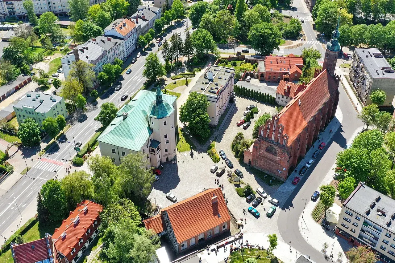 Słupsk atrakcje na weekend: zamek Książąt Pomorskich i kościół Mariacki z lotu ptaka. Zielone dachy i czerwona cegła tworzą malowniczy widok.