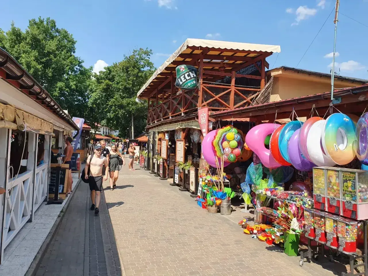 Skorzęcin atrakcje: kolorowe koła do pływania, zabawki i budki z pamiątkami tworzą wakacyjny klimat.