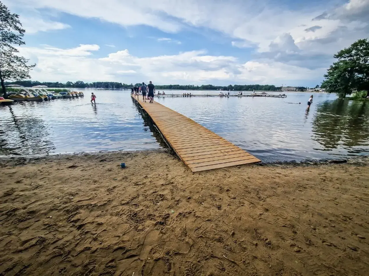 Drewniane molo i plaża nad jeziorem, gdzie można wypożyczyć rowerki wodne. To jedne z wielu atrakcji w Boszkowie.