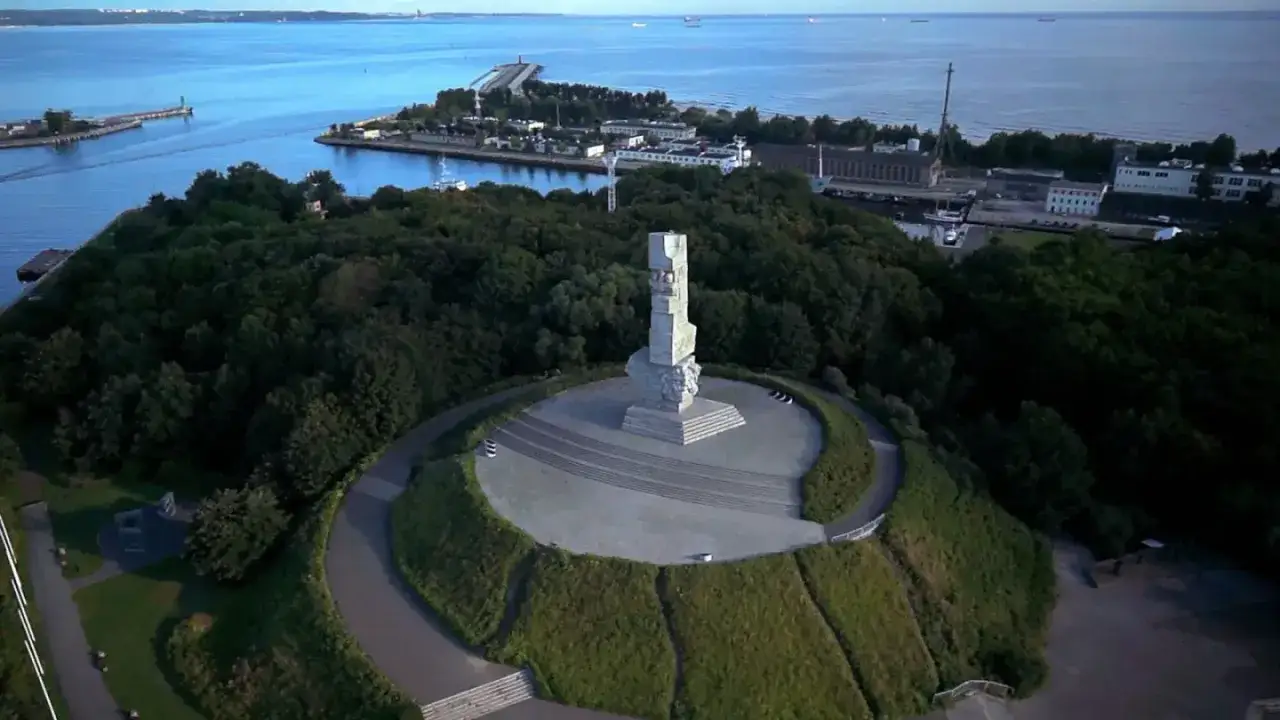 Pomnik Obrońców Wybrzeża na Westerplatte, gdzie leży historia, góruje nad zielonym wzgórzem i wodami Zatoki Gdańskiej.