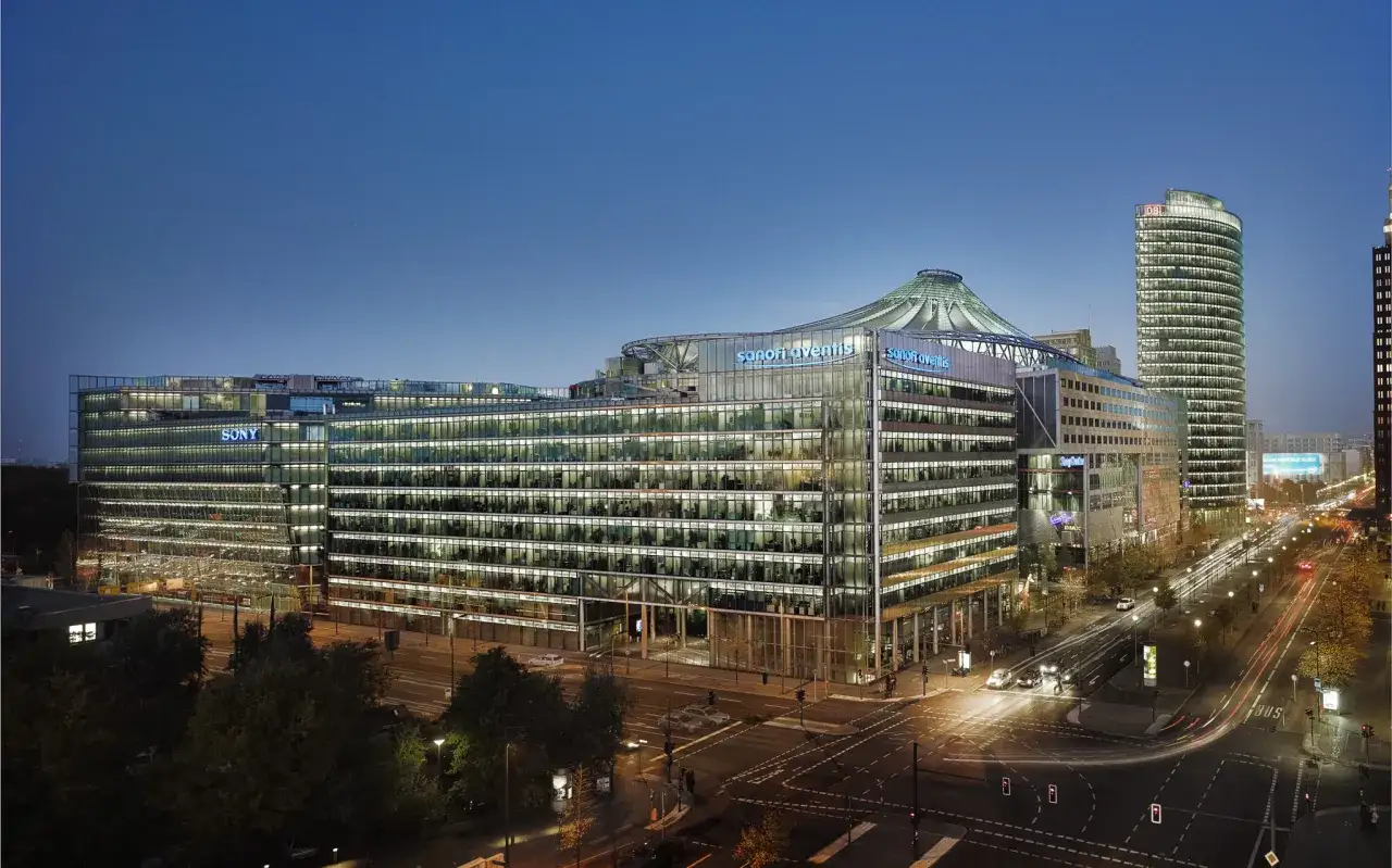 Nowoczesny budynek Sony Center Berlin nocą, z widocznymi światłami biur i neonami.