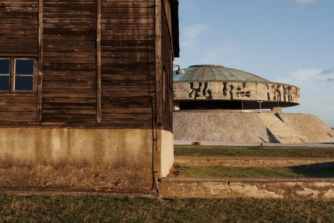 Drewniany barak i monumentalny pomnik na terenie byłego obozu Majdanek.