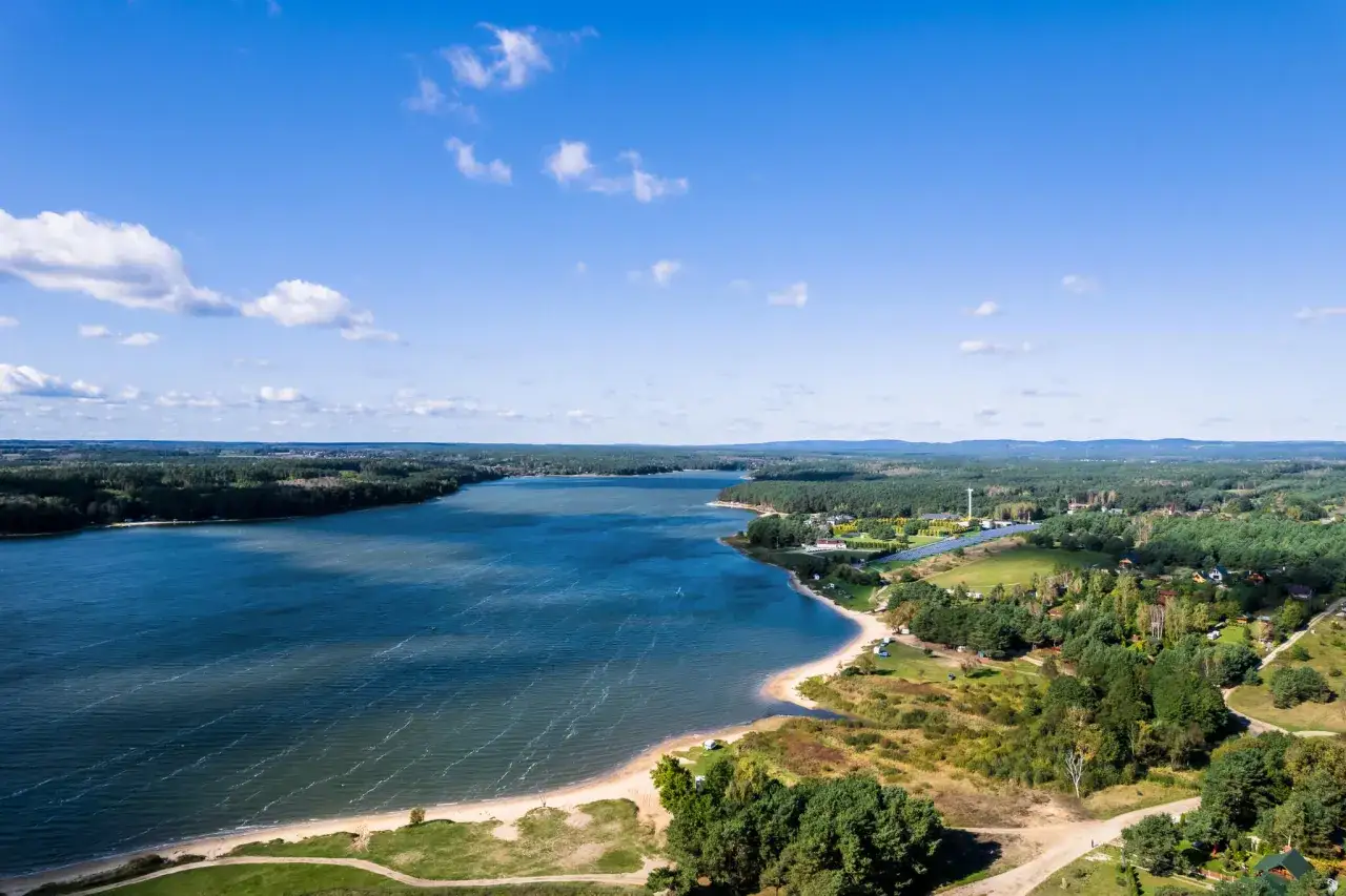 Malownicze jezioro Chańcza z piaszczystą plażą i otaczającymi lasami. Idealne miejsce na wypoczynek, oferujące liczne atrakcje wodne i turystyczne.