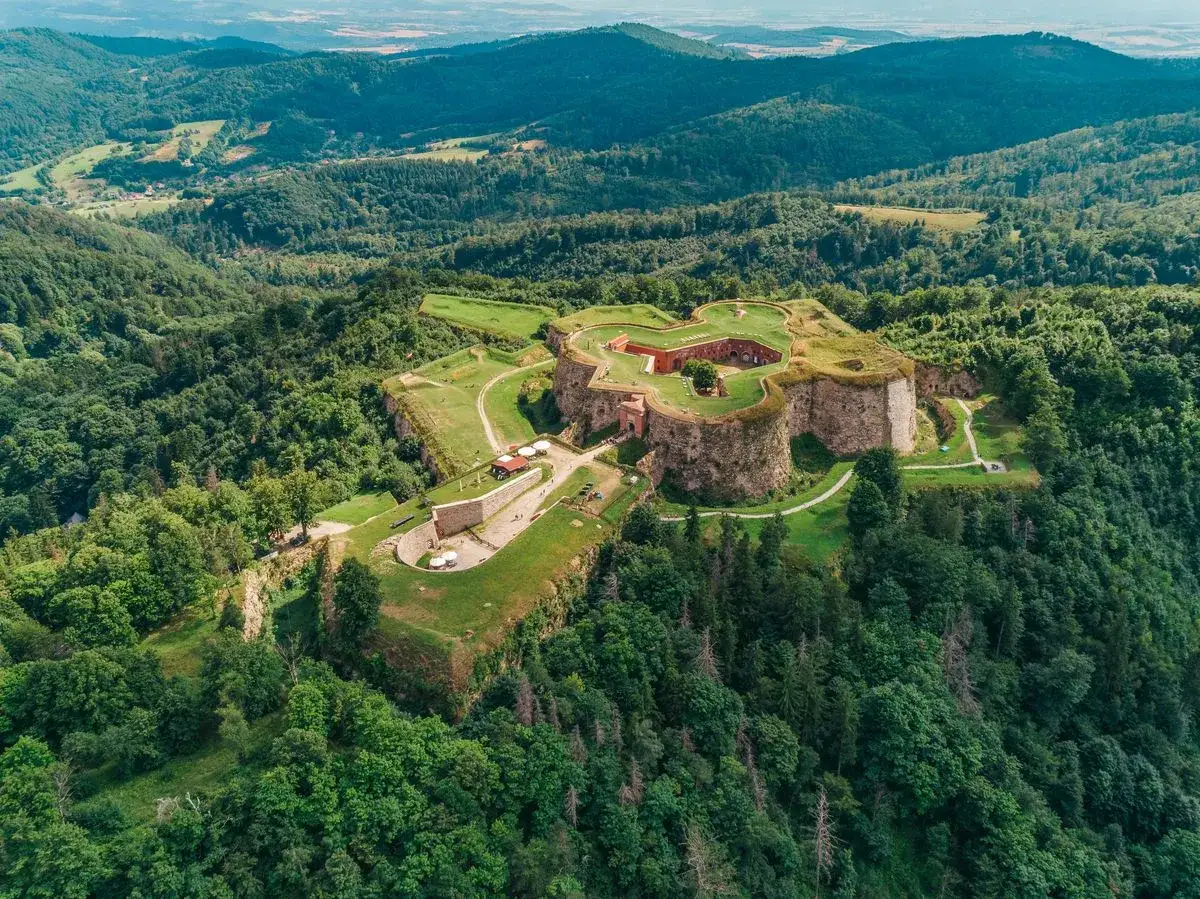 Twierdza Srebrna Góra, imponująca forteca na szczycie wzgórza, otoczona bujnym lasem. Wspaniałe widoki i liczne atrakcje czekają na odkrycie.