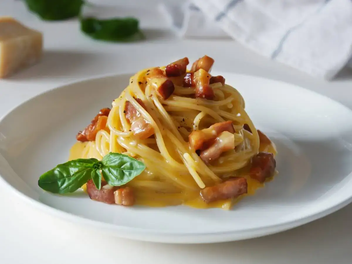 Pyszne spaghetti carbonara z chrupiącym guanciale i kremowym sosem. Idealny ser do carbonary podkreśla smak dania.